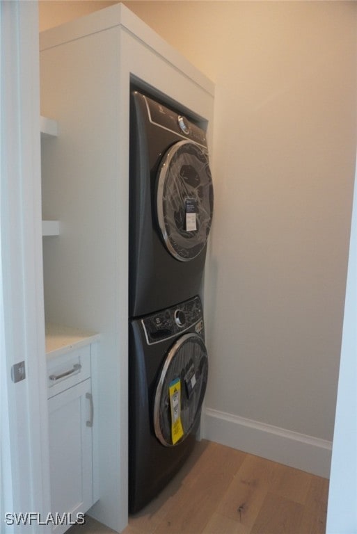 713 Nautilus Ct, Marco Island, FL 34145 - laundry room featuring stacked washer and clothes dryer and light wood-style flooring
