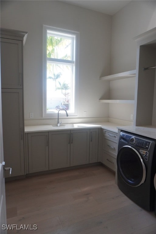 713 Nautilus Ct, Marco Island, FL 34145 - laundry area featuring washer / clothes dryer, cabinet space, light wood-type flooring, and healthy amount of natural light
