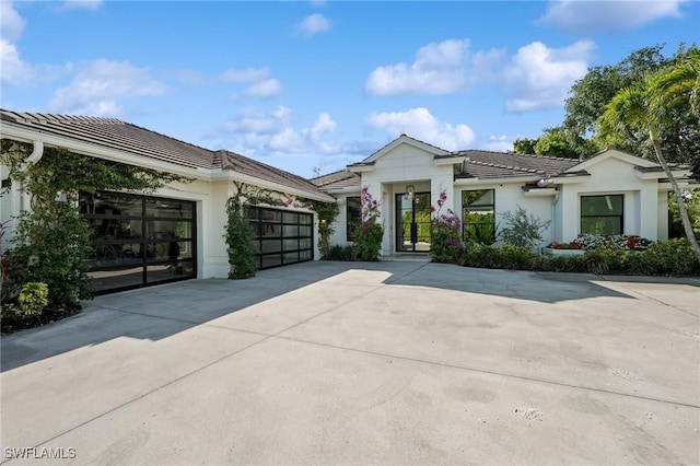 8133 Ronda Ct, Naples, FL 34109 - view of front of house featuring driveway, a tiled roof, an attached garage, and stucco siding