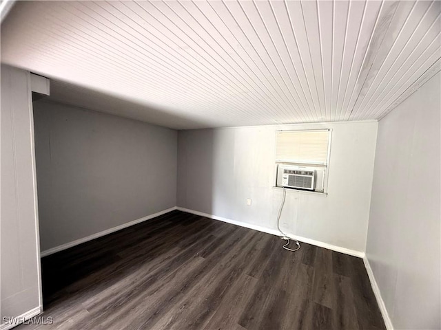 spare room featuring dark wood finished floors, baseboards, cooling unit, and wood ceiling
