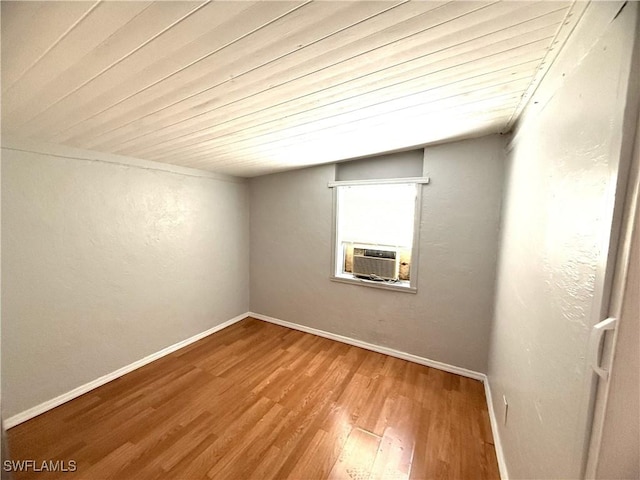 unfurnished room with baseboards, cooling unit, wood finished floors, and wood ceiling