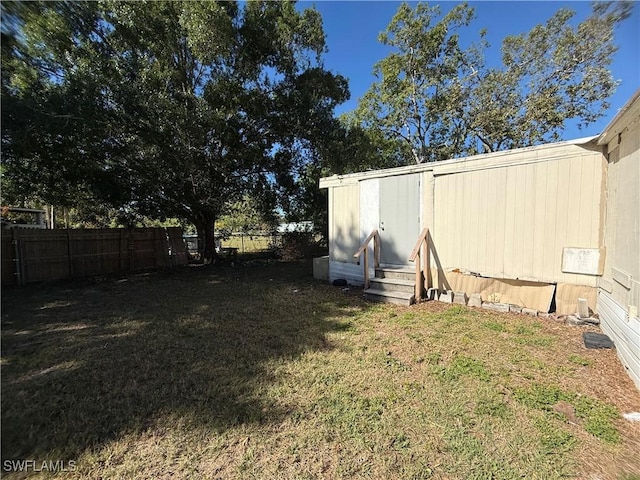 view of yard with a fenced backyard and entry steps