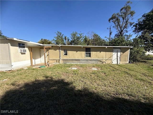 rear view of property with a lawn, cooling unit, and stucco siding