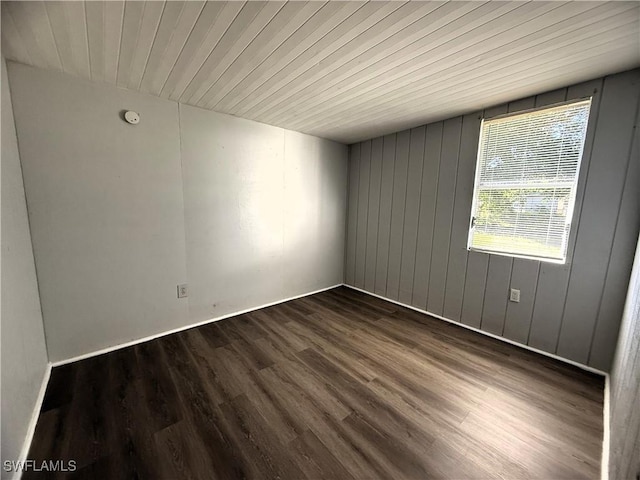 spare room with dark wood-style floors and wood ceiling