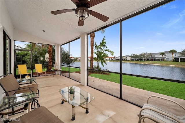 sunroom with a ceiling fan, a water view, and vaulted ceiling