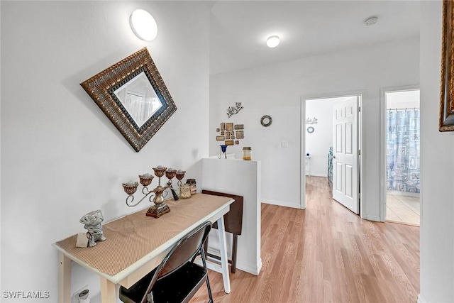 corridor featuring baseboards and light wood-style floors