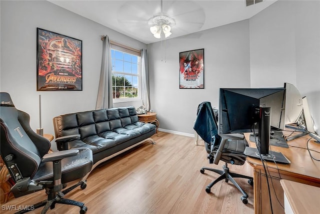 home office with a ceiling fan, wood finished floors, visible vents, and baseboards