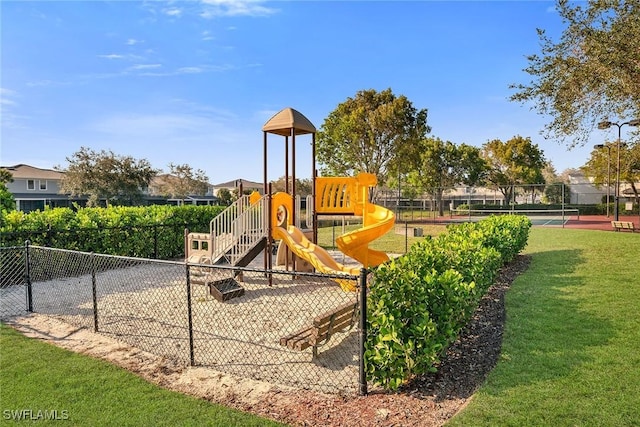 community play area with a lawn and fence