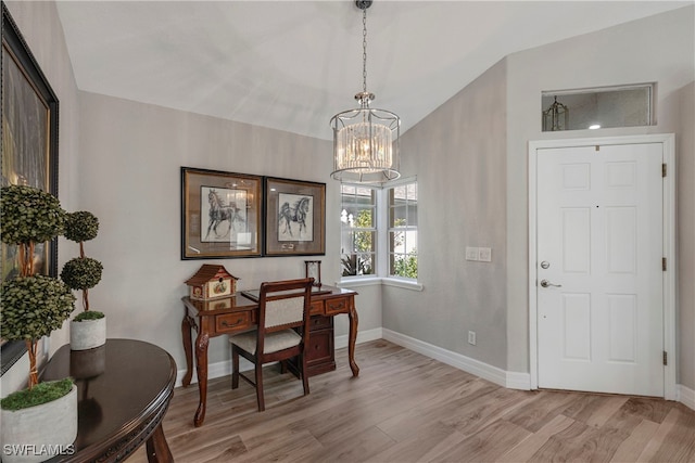 home office featuring lofted ceiling, light wood finished floors, baseboards, and a chandelier