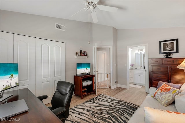 office with lofted ceiling, a ceiling fan, baseboards, visible vents, and light wood-style floors