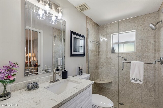 bathroom with visible vents, a shower stall, toilet, and vanity