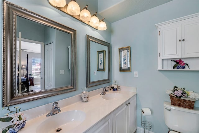 full bathroom with a sink, toilet, and double vanity