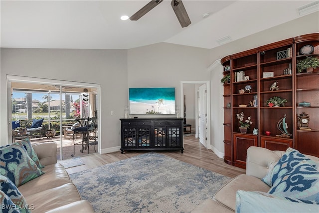 living area featuring a ceiling fan, visible vents, vaulted ceiling, and wood finished floors