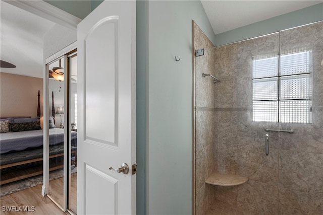 bathroom featuring a stall shower, connected bathroom, and wood finished floors