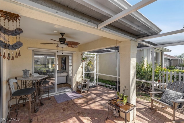 view of patio / terrace with a ceiling fan and glass enclosure