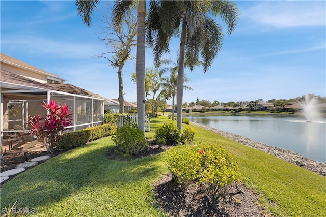 view of yard with a lanai and a water view