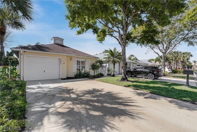 view of front of home with a garage, driveway, and stucco siding