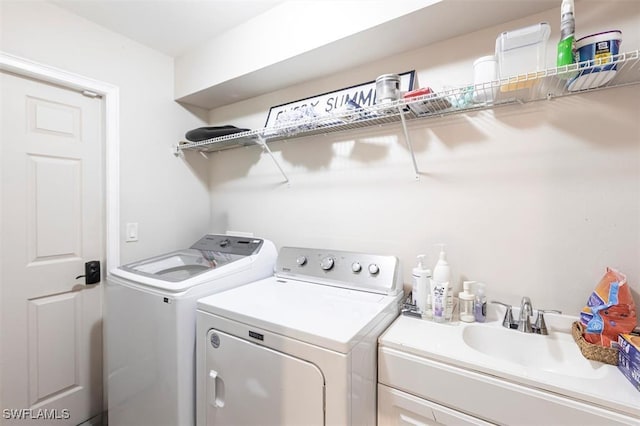 washroom featuring laundry area, a sink, and washer and dryer