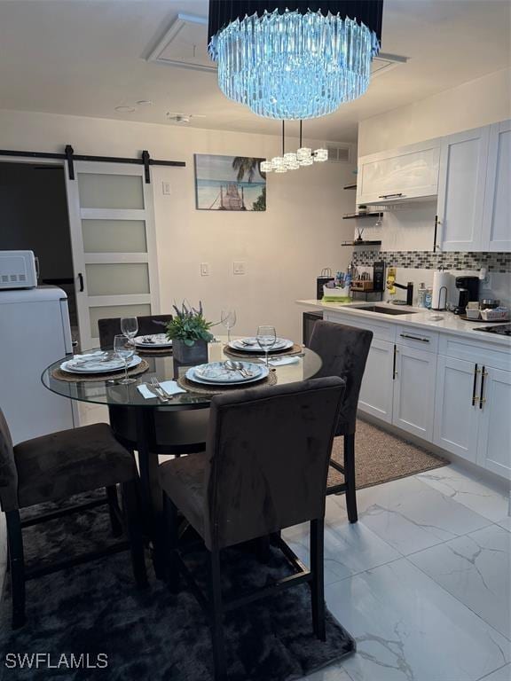 dining space with washer / clothes dryer, marble finish floor, and a barn door