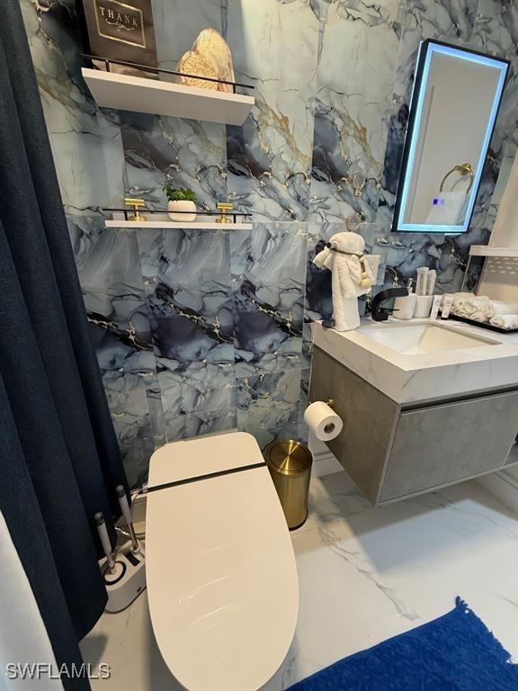 bathroom with marble finish floor and vanity