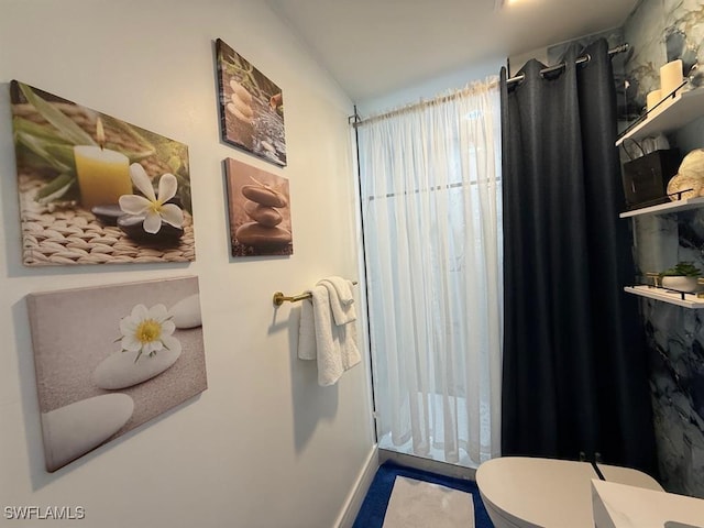 bathroom with baseboards and toilet