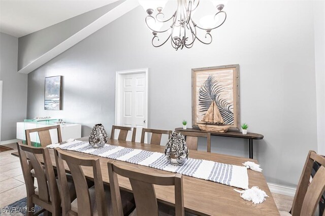 dining area with light tile patterned floors, vaulted ceiling, baseboards, and a notable chandelier