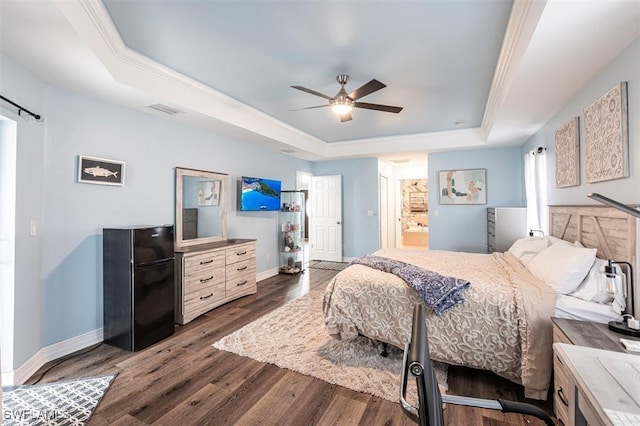 bedroom with visible vents, dark wood finished floors, a ceiling fan, baseboards, and a tray ceiling