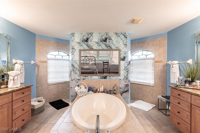 full bathroom with a bath, tile patterned flooring, walk in shower, vanity, and tile walls