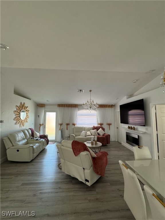 living area featuring vaulted ceiling, wood finished floors, and visible vents