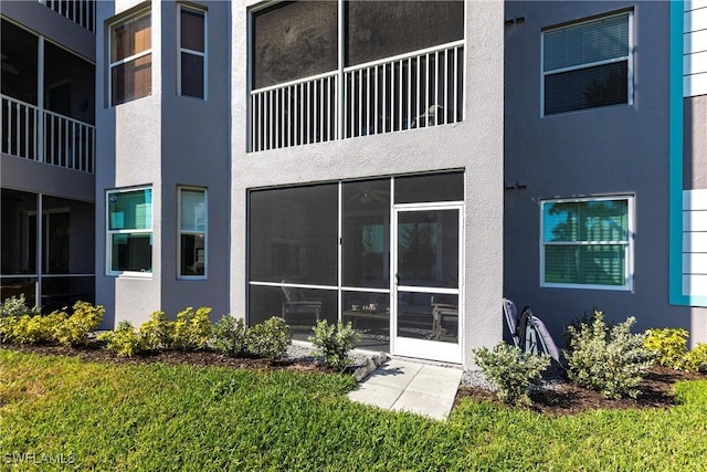 exterior space featuring a sunroom and stucco siding