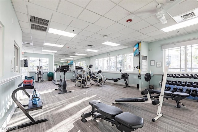 exercise room featuring a wealth of natural light, visible vents, and carpet flooring