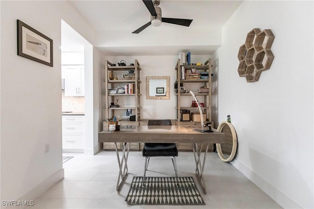 office area featuring a ceiling fan and baseboards