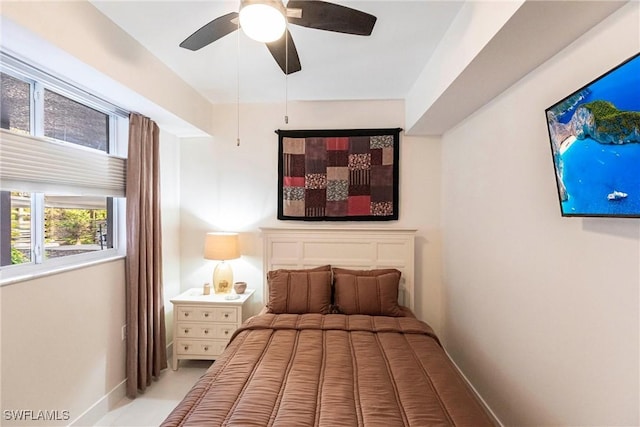 bedroom with a ceiling fan and baseboards