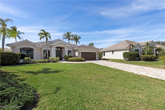 view of front facade with a garage, a front lawn, decorative driveway, and stucco siding