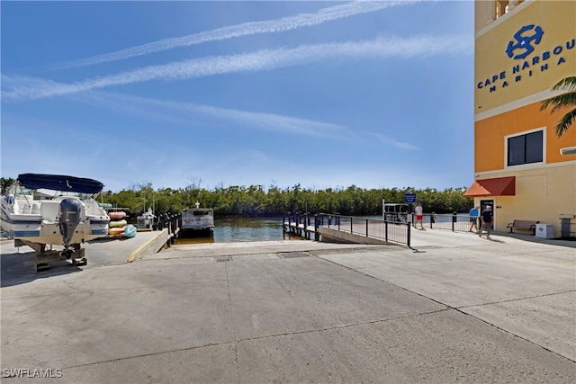 view of vehicle parking with a dock and a water view