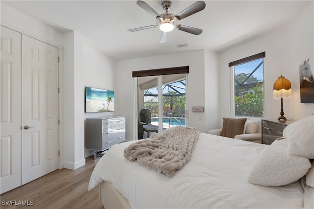 bedroom featuring access to exterior, visible vents, a sunroom, ceiling fan, and wood finished floors