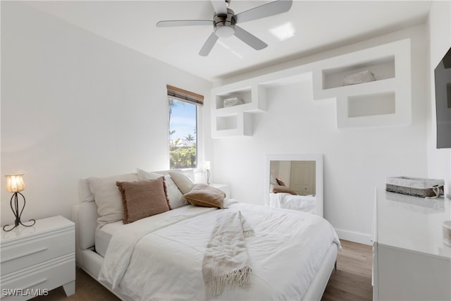 bedroom featuring baseboards, dark wood finished floors, and a ceiling fan