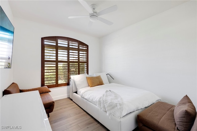 bedroom with light wood-style floors, ceiling fan, and baseboards