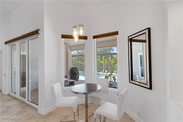 dining room with a sunroom and baseboards