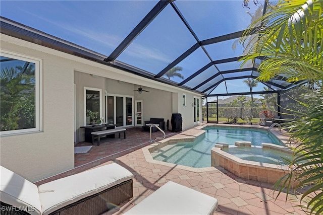 view of pool with a patio, a pool with connected hot tub, a lanai, and a ceiling fan