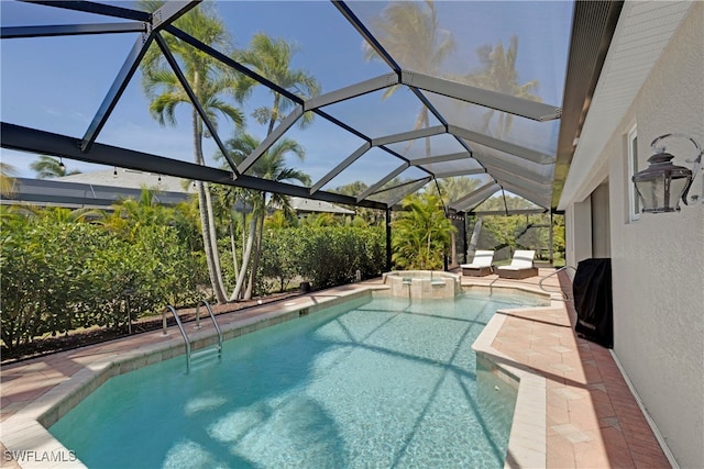 view of pool featuring a lanai, a pool with connected hot tub, and a patio