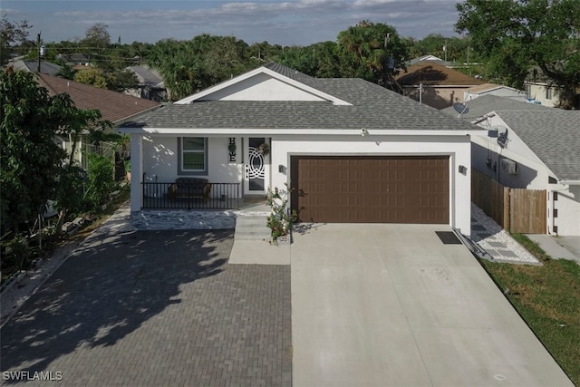 ranch-style home with stucco siding, an attached garage, roof with shingles, and driveway