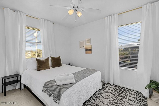 7431 Barrancas Ave, Bokeelia, FL 33922 - bedroom with light tile patterned floors and a ceiling fan