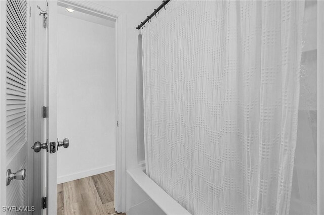 7431 Barrancas Ave, Bokeelia, FL 33922 - interior space featuring shower / bathtub combination with curtain and wood finished floors