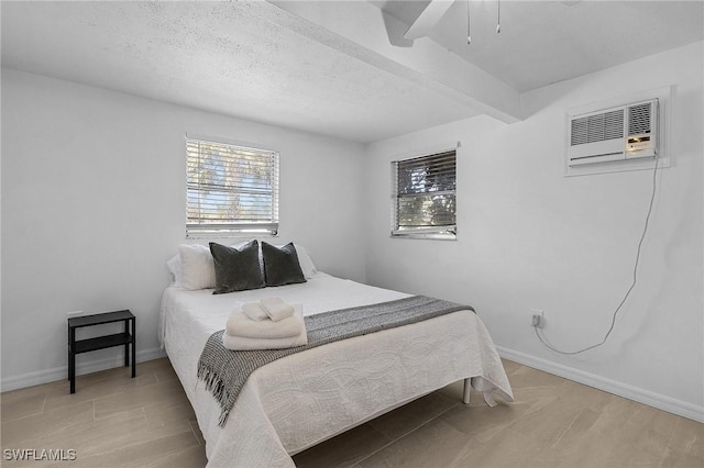 7431 Barrancas Ave, Bokeelia, FL 33922 - bedroom with a textured ceiling, baseboards, wood finished floors, and a wall mounted AC