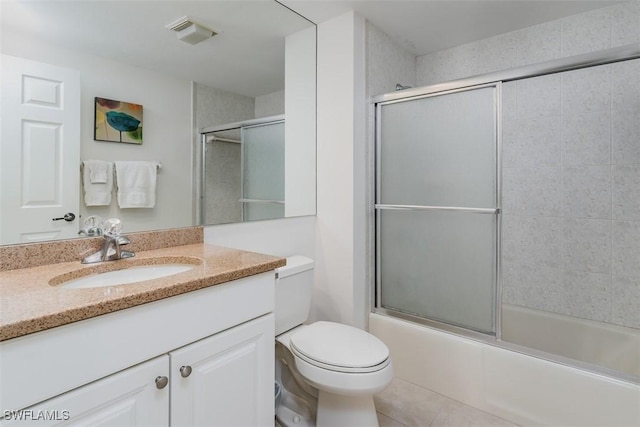 bathroom with tile patterned flooring, toilet, visible vents, vanity, and combined bath / shower with glass door