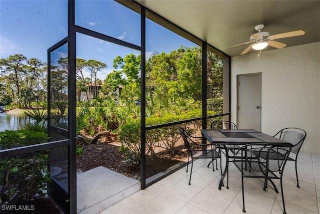 sunroom featuring a water view and ceiling fan