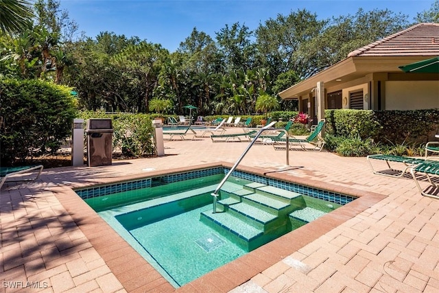 community pool with a community hot tub and a patio area