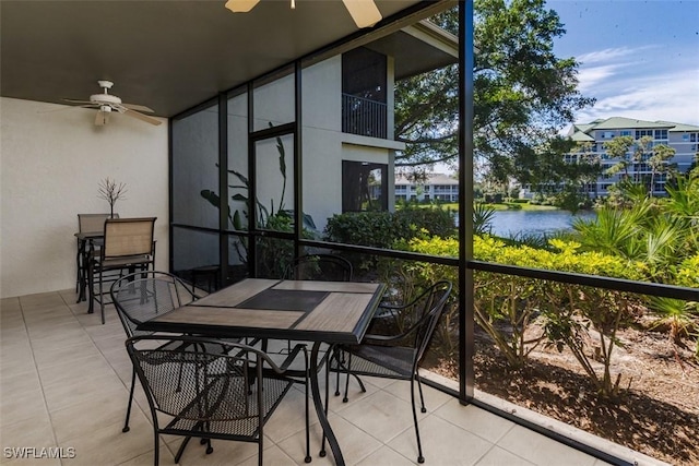 sunroom featuring a water view and a ceiling fan