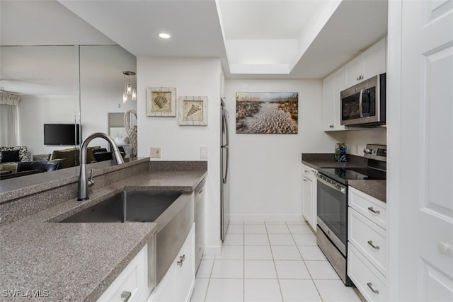 kitchen featuring light tile patterned floors, open floor plan, stainless steel appliances, white cabinetry, and recessed lighting